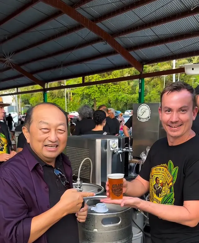 Dois participantes brindando com chopp ao lado de um barril na Mostra de Jazz & Blues